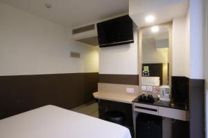 um pequeno quarto com uma cama e uma pequena cozinha em The Snooze Hotel at Bugis em Singapura