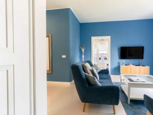a living room with blue walls and a blue couch at Aquamarine Sea View Apartment in Zadar