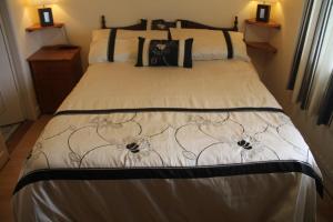 a bedroom with a bed with a black and white comforter at Marguerite's B&B in Skibbereen