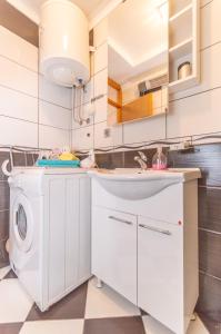 a white kitchen with a washer and dryer at Apartment Risan in Risan