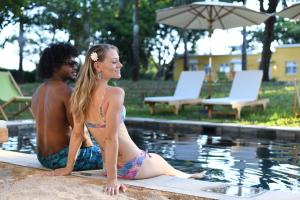 um homem e uma mulher sentados ao lado de uma piscina em Kaz'alala Hosted B&B em Bel Ombre