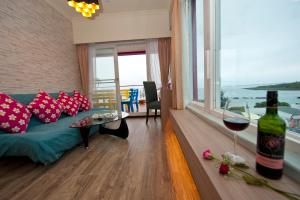 a living room with a couch and a bottle of wine at 墾丁品喬旅店 in Eluan