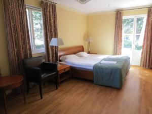 a bedroom with a bed and a desk and a chair at Hotel Laurenti in Söderköping