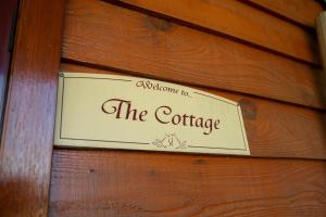a sign on a wooden wall that reads the cottage at Vivere Retreat in Neerim South