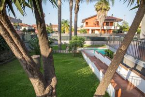 a backyard with palm trees and a swimming pool at Antichi Ricordi in Aci SantʼAntonio