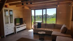 a living room with a couch and a television at Mazurskie Ranczo in Bogaczewo