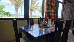 a dining room table with a view of the ocean at Summerhouse Peggy: close to Athens airport by the sea in Artemida