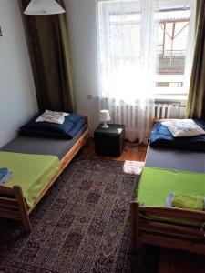 a bedroom with two beds and a window at Przy Starej Lipie in Augustów