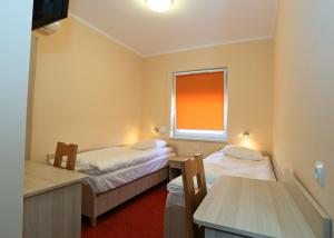 a small room with two beds and a window at Hostel Żywiec in Żywiec