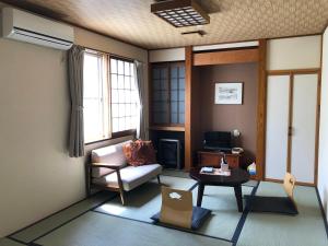 uma sala de estar com um sofá e uma mesa em Tabinoyado Saikawa em Kuroishi