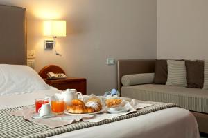 ein Tablett mit Essen auf einem Bett in einem Hotelzimmer in der Unterkunft Hotel Villa Luisa in Pozzuoli