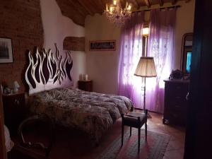 een slaapkamer met een bed en een kroonluchter bij Luna Ridens in Alberese