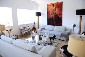 una sala de estar con sofás blancos y una mesa. en Maison l'Etrier, en Saintes-Maries-de-la-Mer