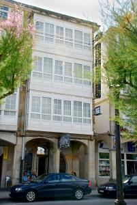 un coche azul estacionado frente a un edificio en Pensión Residencia J. Lago, en Muros