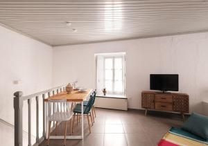 a dining room with a table and a television at Keresbino Hydra Port House in Hydra