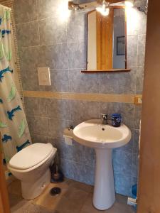 een badkamer met een wastafel, een toilet en een spiegel bij Luna Ridens in Alberese