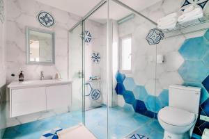 y baño azul y blanco con aseo y ducha. en Party of the Ocean B&B, en Magong