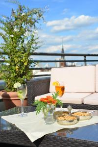 a table with two plates of food and drinks on a balcony at Hotel Domicil Berlin by Golden Tulip in Berlin