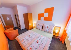 a bedroom with a bed with an orange headboard at Penzion U Jezku in Blansko