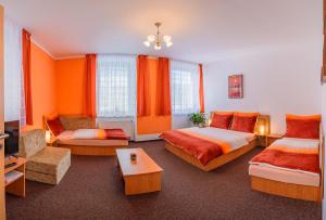 ブランスコにあるPenzion U Jezkuのベッド2台とソファが備わるホテルルームです。