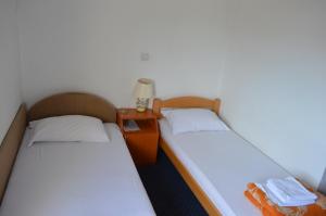 two twin beds in a room with a night stand at Motel Signal in Banja Luka