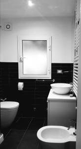 a black and white bathroom with a toilet and a sink at Casa Maya con giardino privato in Torre del Lago Puccini