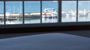 a bedroom with a window with a view of a marina at Apartamentos Timón Puerto in O Grove