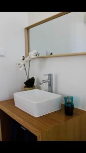 a white sink on a wooden counter with a mirror at Back to Lisbon Hostel in Lisbon
