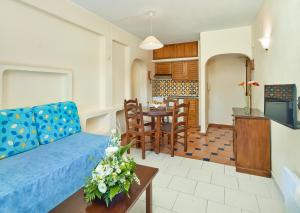 - un salon avec un canapé bleu et une table dans l'établissement Cheerfulway Ouravista Apartamentos, à Albufeira