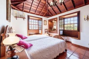 ein Schlafzimmer mit einem großen Bett mit rosa Kissen in der Unterkunft Casa Rural Fidel in Breña