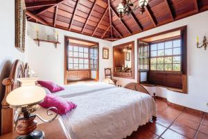 1 dormitorio con 1 cama grande con almohadas rosas en Casa Rural Fidel, en Breña