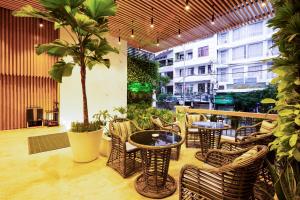 ニャチャンにあるErica Nha Trang Hotelのヤシの木のあるパティオ(椅子、テーブル付)