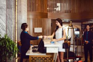 ニャチャンにあるErica Nha Trang Hotelの男女がカウンターで握手 +96枚の写真