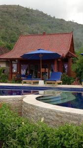a house with a swimming pool in front of a house at Good Karma Bungalows in Amed