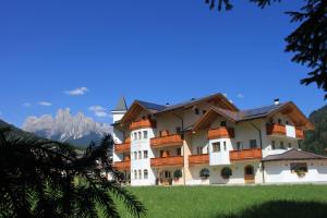 a large building with a mountain in the background at Hotel Garnì Paradisi - Wellness & Spa in Mezzano