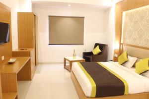 Hotel Aero Star Near Delhi Airport في نيودلهي: غرفة فندق بسرير وشاشة عرض