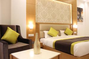 a hotel room with a bed and a chair at Hotel Aero Star Near Delhi Airport in New Delhi