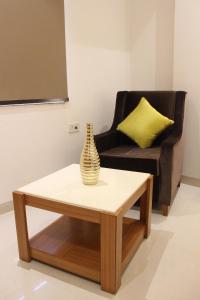 a vase sitting on a coffee table next to a chair at Hotel Aero Star Near Delhi Airport in New Delhi