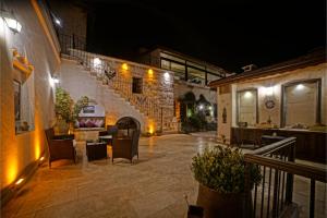 a patio with chairs and a staircase at night at Mira Cappadocia Hotel in Avanos