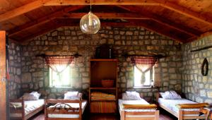 a room with two beds and two windows at Rent House Orahovo in Virpazar