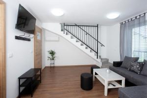 un soggiorno con divano e una scala di Apartments Razingar 9 a Bled
