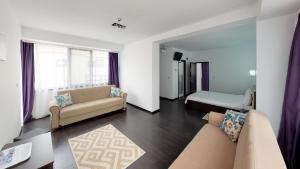 a living room with a couch and a bed at Matei Mamaia-Nord in Mamaia Sat/Năvodari