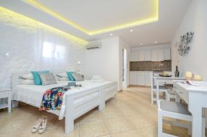 1 dormitorio blanco con 1 cama y cocina en Summer Memories Studios, en Naxos Chora