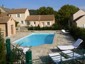 a swimming pool with two chairs and a house at Domaine De La Combotte in Nantoux