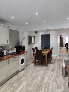 a kitchen and dining room with a table and a washer at Dobbies Adults Only Boutique Apartment in Saint-Marcel