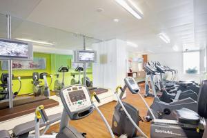 a gym with treadmills and elliptical machines at Mövenpick Hotel Zurich Airport in Glattbrugg