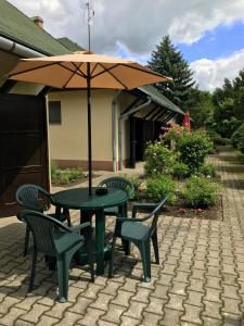 a table and chairs with an umbrella on a patio at Fűz Apartman in Balatonfůzfő