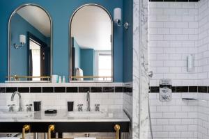 
a bathroom with two sinks and a mirror at Hôtel Longemalle in Geneva
