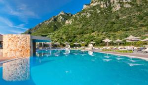 a swimming pool with a mountain in the background at Kyniska Palace Conference & Spa in Mystras