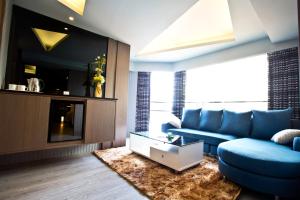 sala de estar con sofá azul y TV en Fine Hotel en Kaohsiung